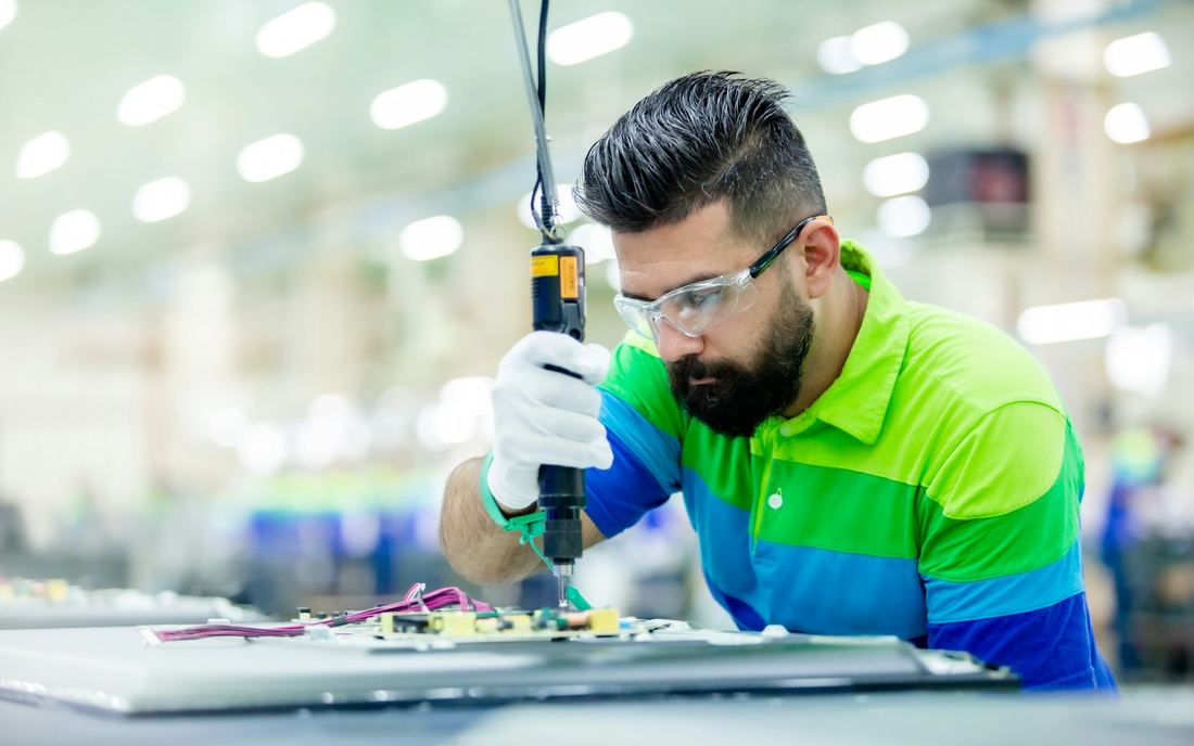 Técnico con gafas de seguridad trabajando en una fábrica